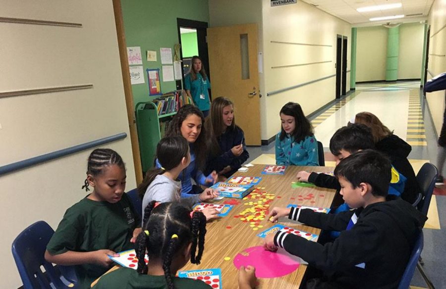 Soccer players Charlotte Teeter and Julia Schukle teach fourth graders the importance of math through a game of Bingo.