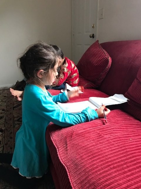 Carloss daughter, who is working hard on schoolwork.