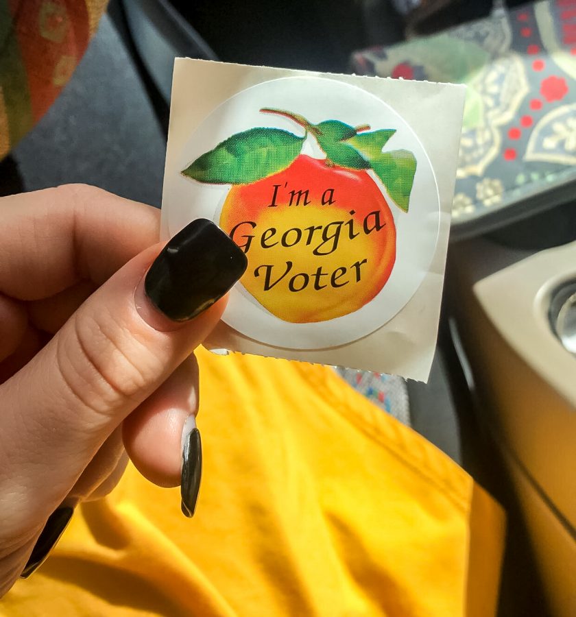 Senior Maggie Martin proudly shows off the Im a Georgia Voter  sticker she got after early voting.