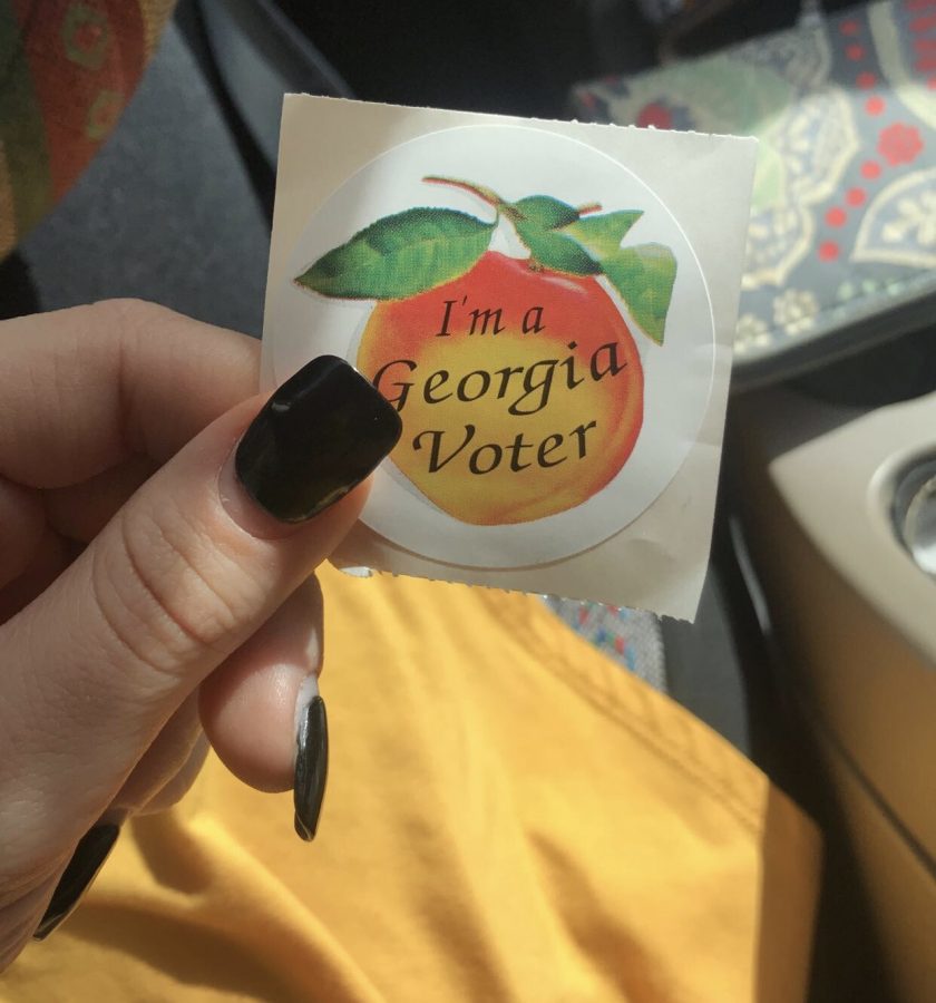Senior Maggie Martin proudly shows off the Im a Georgia Voter  sticker she got after early voting.