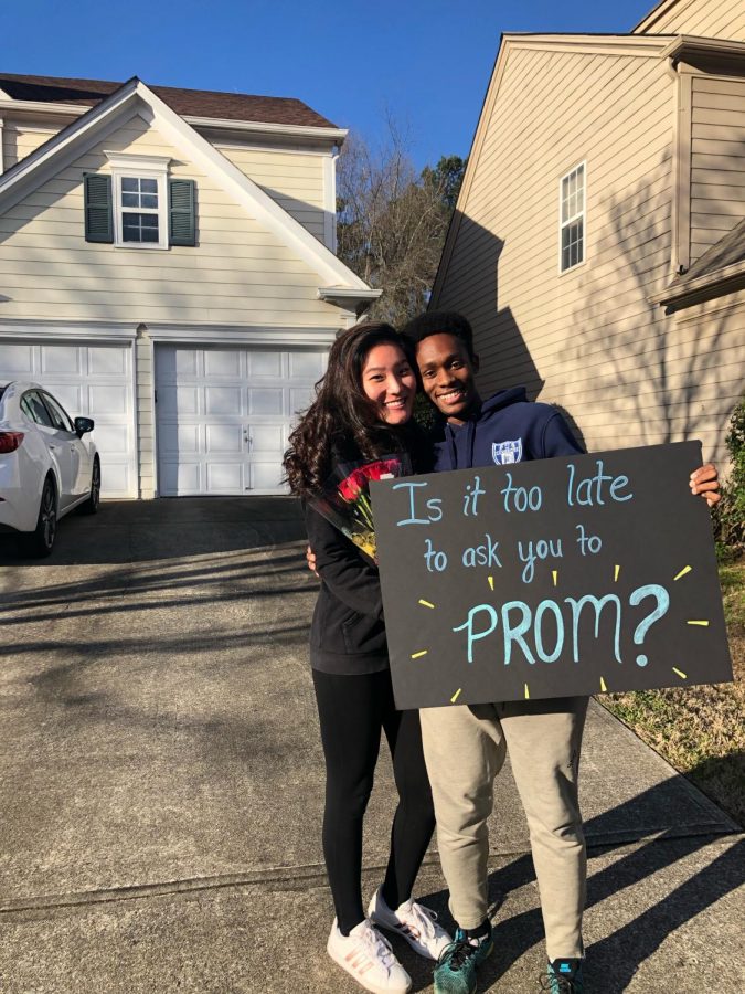 Junior Kamal Barnes asks Allison Lee, also a junior, to prom with a poster and flowers.