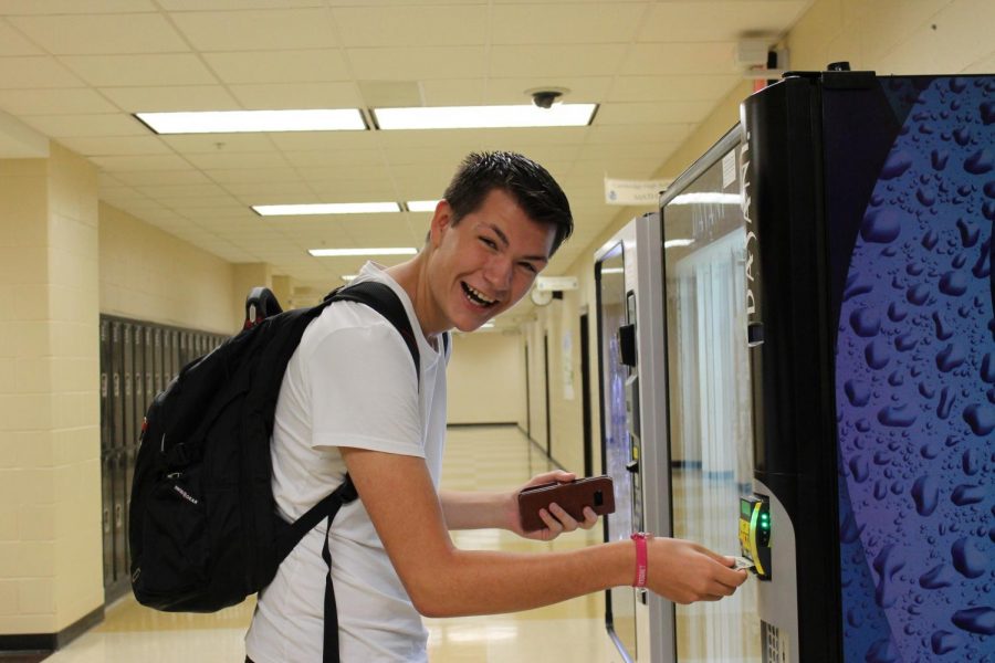 Swedish exchange student BoAlbin Persson poses as he uses a vending machine for the first time.