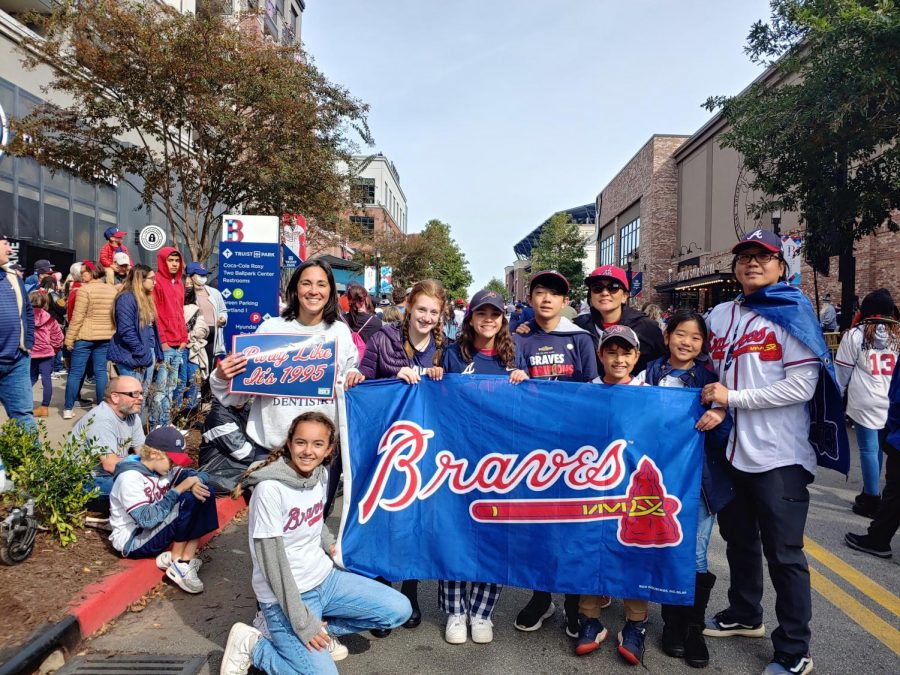 Kim and his family hold up a Braves banner at the parade on Friday.