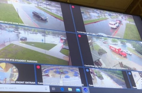 A screen in the front office shows multiple camera angles from outside the building.