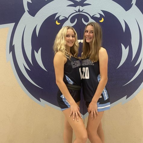 Ella and Raygen pose for a photo in their jerseys in front of the bear mural.
