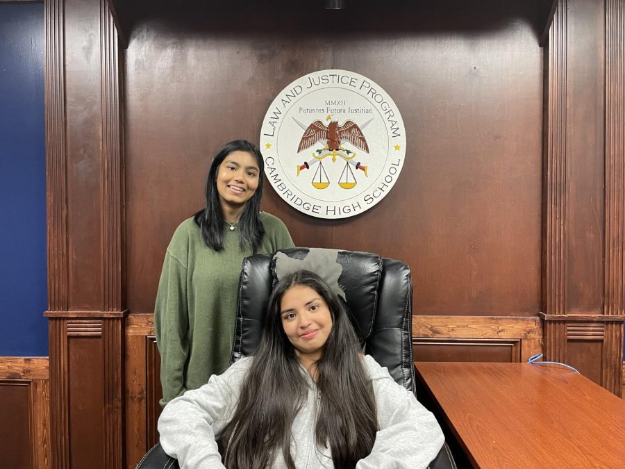 Rachanreddy (standing up) and Alvarado (sitting down) pose for a photo in the mock courtroom.