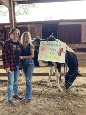 Ian Chaffin (left) with homecoming poster in stable with girlfriend Ava Ritter (right)