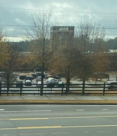 Police cars in front of the school as seen from across the street.