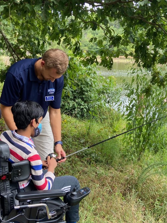 Sophomore Shaik fishing with his paraprofessional Carson Hollingsworth in the woods together. 